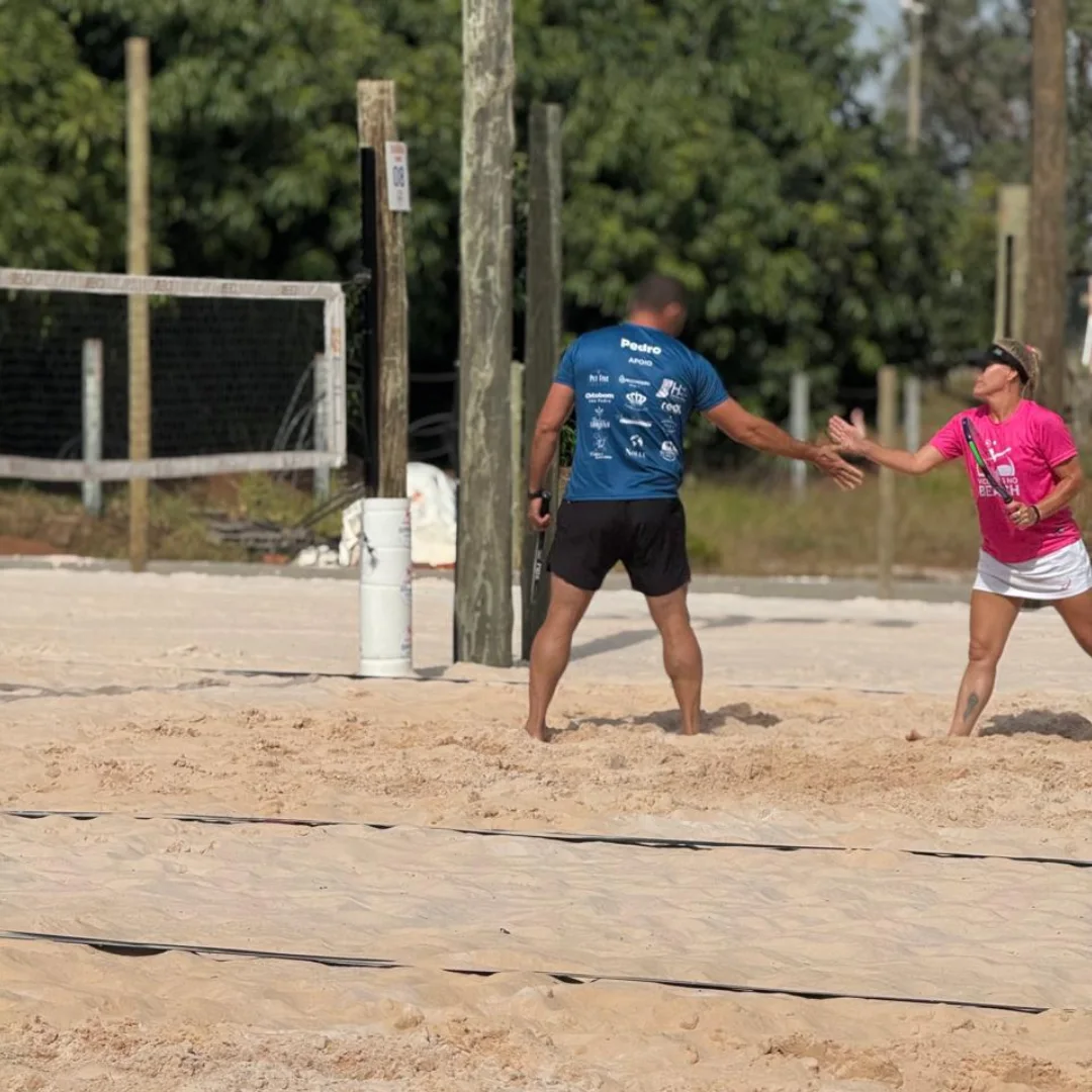 Atletas se cumprimentam na areia